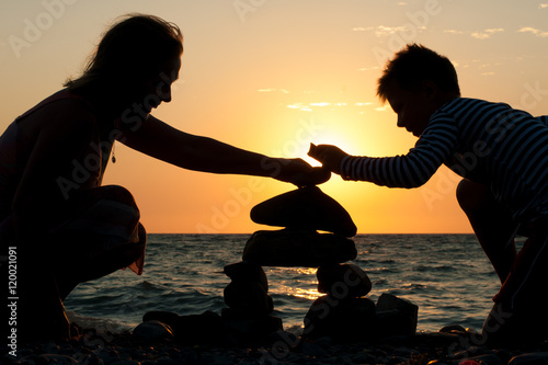 grandmother with her grandson on the beach at sunset