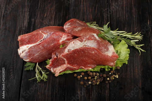 beef with spices on wooden background