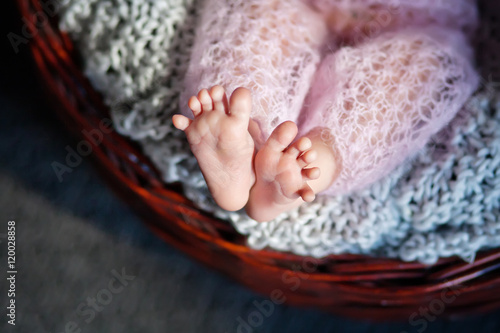 Close up picture of new born baby feet on knitted plaid in a wat