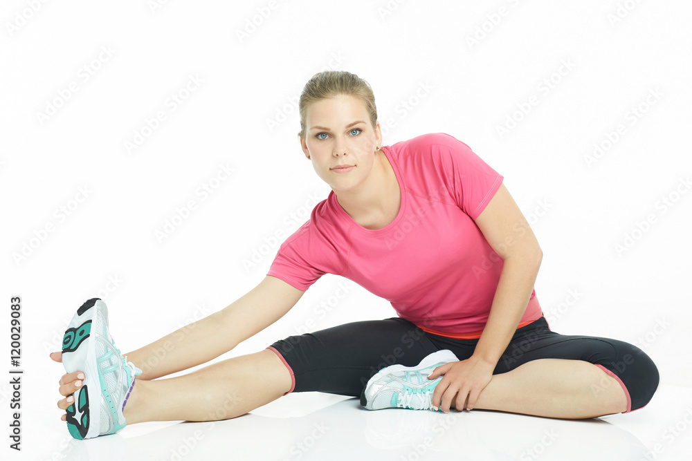 Young caucasian woman stretching legs before doing her workout. Woman warming up before workout in studio isolated on white background. Young caucasian woman stretching legs before doing her workout. Woman warming up before workout in studio isolated on white background.