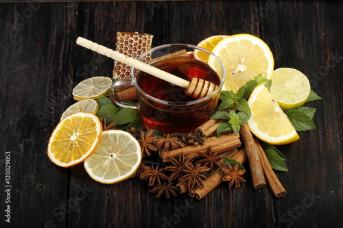 tea with honey and spices on wooden background