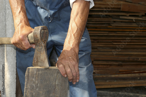 The worker, a man with an ax chopping firewood . Employee.