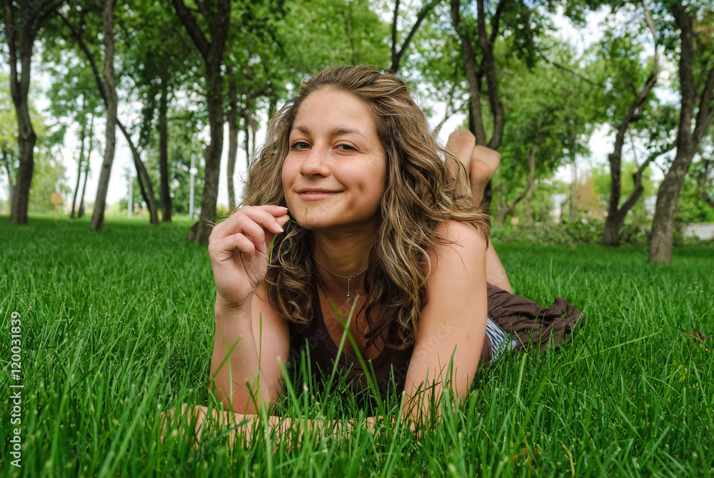 Young beautiful smiling woman lays on grass Young beautiful smiling woman lays on grass