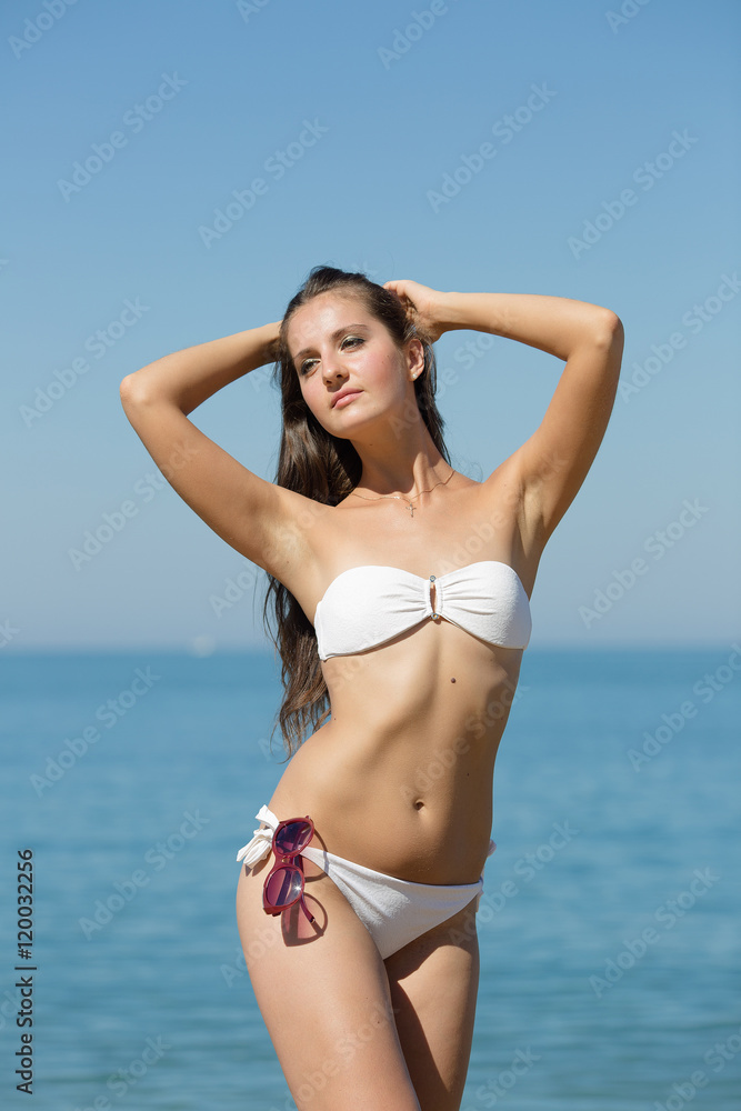 Attractive girl in white bikini against sea Attractive girl in white bikini against sea