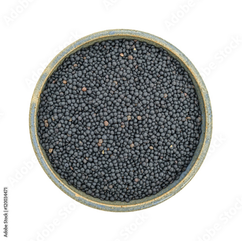 Black beluga lentils in a stoneware bowl top view on a white background.