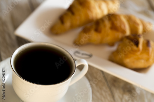 Croissants with coffee on the wooden table