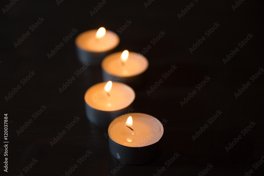 Lit candles one behind the other viewed with depth of field Lit candles one behind the other viewed with depth of field