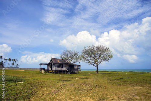 Fotografi Old abandoned house under blue sky near the beach.