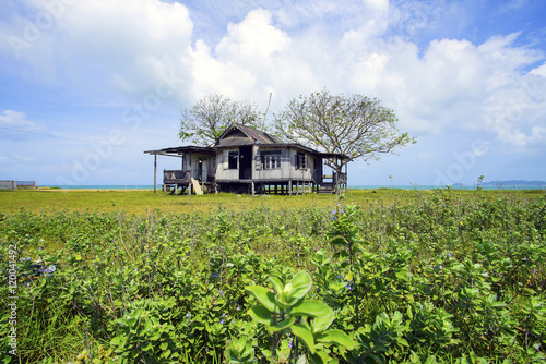 Old abandoned house under blue sky near the beach. © nelzajamal