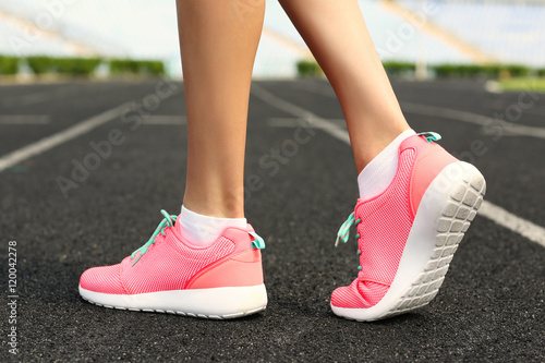 Woman wearing pink sneakers on a running stadium