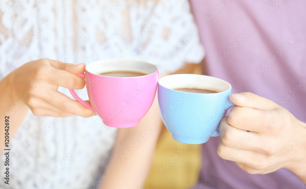 Couple holding cups of coffee together Couple holding cups of coffee together