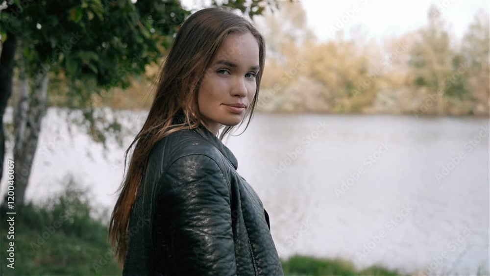 Student Model Looks Around, smiling and make some flirt.Camera Follows Behind Teen Girl Walking Through City Park. Student Model Looks Around, smiling and make some flirt.Camera Follows Behind Teen Girl Walking Through City Park.