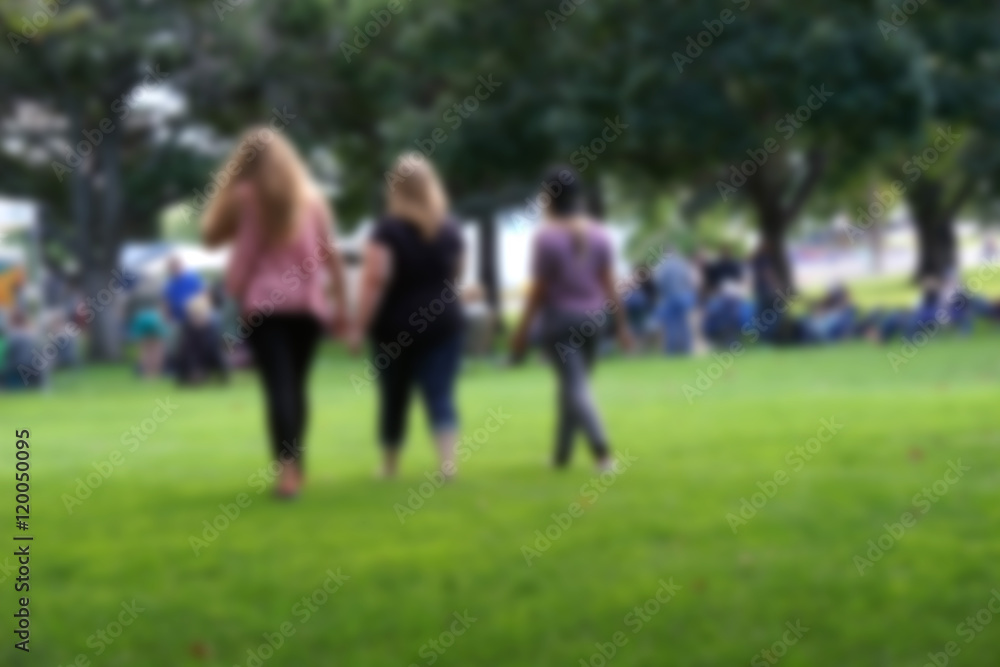 blur background of people walking through park blur background of people walking through park