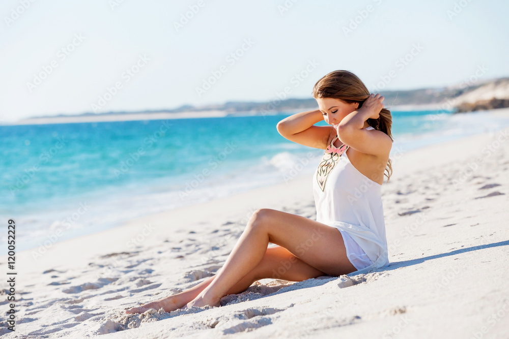 Young woman sitting on the beach Young woman sitting on the beach