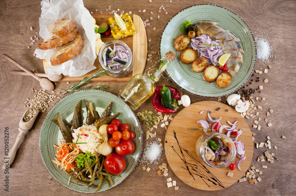 Different vegetables, meat, red fish and other dishes, sauces, snacks and spices on a wooden background