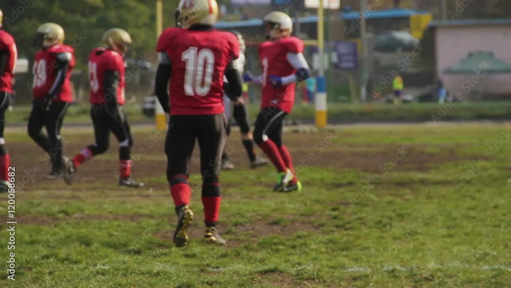 Player running to position on pitch with a ball, American football game, sports Player running to position on pitch with a ball, American football game, sports