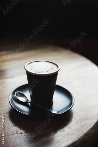 Moody restaurant setting with cafef latte by window light photo