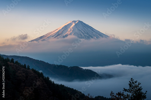 Mount Fuji enshrouded in clouds with clear sky from lake kawaguchi, Yamanashi, Japan photo