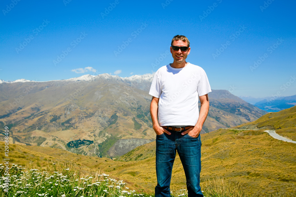 Young man standing on the top of the Mount. Mt Aspiring landscape in Wanaka, New Zealand