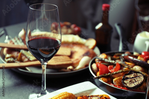 Glass of wine and grilled vegetables on served table