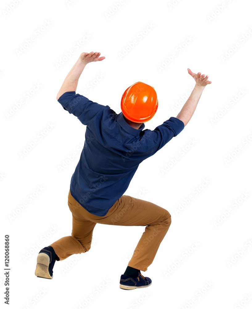 back view business man protective construction helmet protects hands from what is falling from above. Isolated over white background. a man wearing a helmet holds a heaviness above your head. back view business man protective construction helmet protects hands from what is falling from above. Isolated over white background. a man wearing a helmet holds a heaviness above your head.
