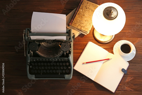 Old typewriter and notebook on the table, top view