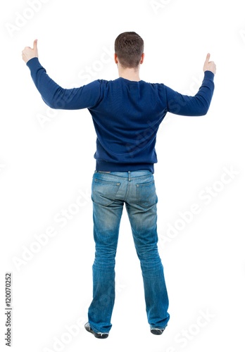 Back view of business man shows thumbs up. bearded man in blue pullover showing thumbs up with both hands.