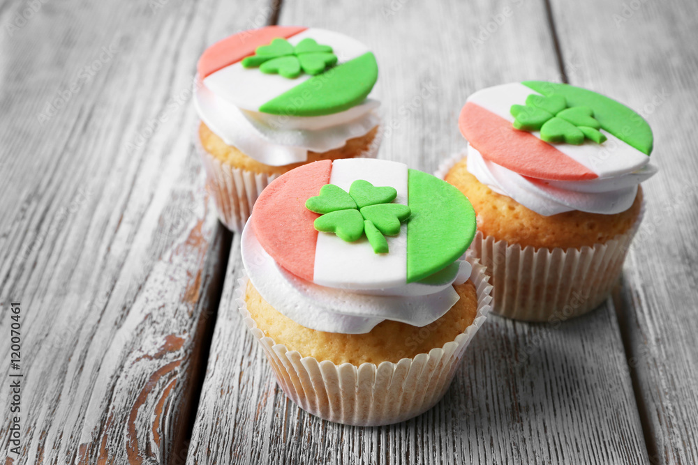 Tasty cupcakes with clover on wooden background. Saint Patrics Day concept Tasty cupcakes with clover on wooden background. Saint Patrics Day concept
