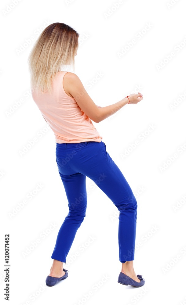 back view of standing girl pulling a rope from the top or cling to something. Isolated over white background. The blonde in a pink shirt pulling rope. back view of standing girl pulling a rope from the top or cling to something. Isolated over white background. The blonde in a pink shirt pulling rope.