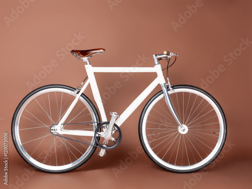 Fixed Gear beautiful vintage bicycle stands on a brown background