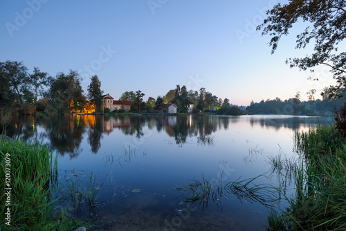 Evening landscape with the river and houses on the other bank