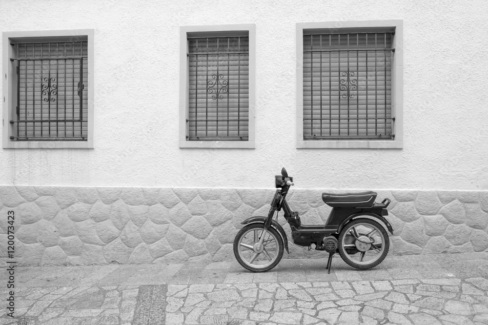 Typical Spanish old motorcycle parked in the street.