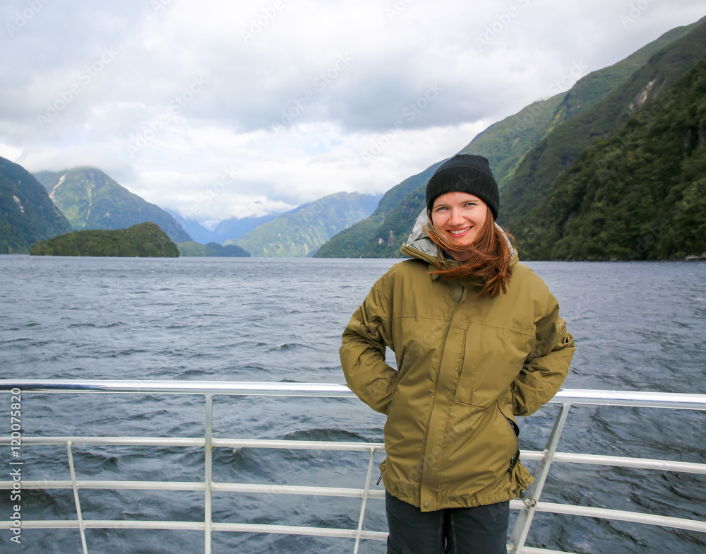 Young smiling woman  standing on the deck of touring boat. New Zealand