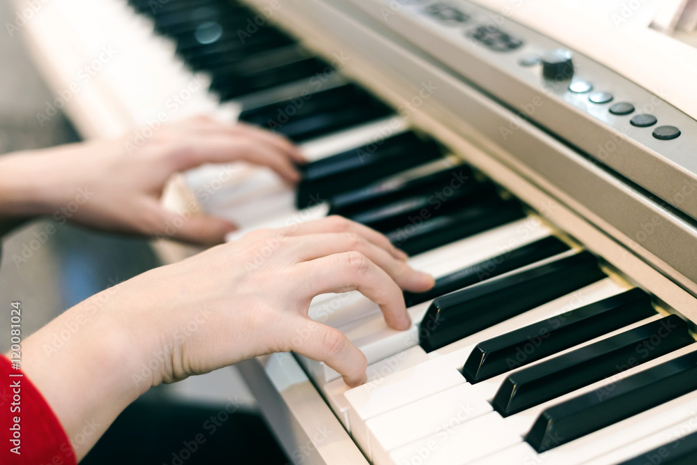 Fototapeta premium Girl's hands playing piano, selective focus