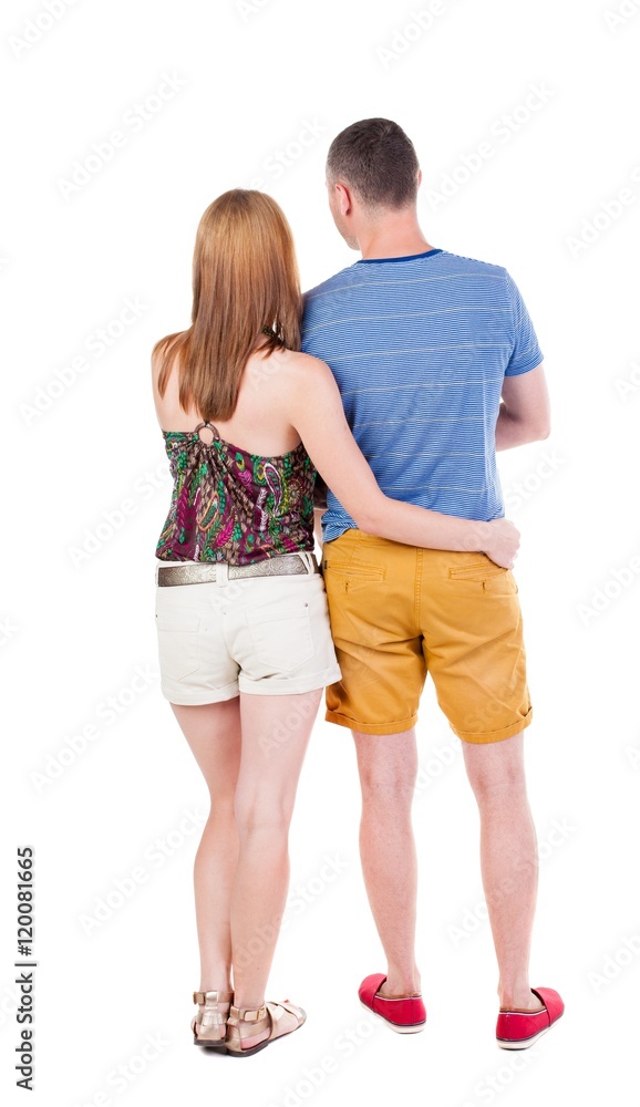 Back view of young embracing couple in shorts hug and look. friendly girl and guy together. Rear view people collection. backside view of person. Isolated over white background. Back view of young embracing couple in shorts hug and look. friendly girl and guy together. Rear view people collection. backside view of person. Isolated over white background.