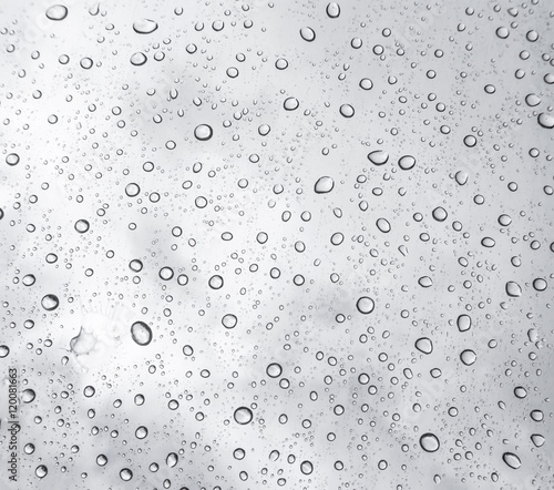 Drops of rain on glass , rain drops on clear window / rain drops with clouds / water drops on glass after rain background / water drops / Small water drops on the glass.