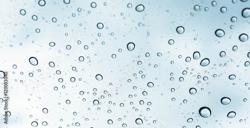 Drops of rain on glass , rain drops on clear window / rain drops with clouds / water drops on glass after rain background / water drops / Small water drops on the glass.
