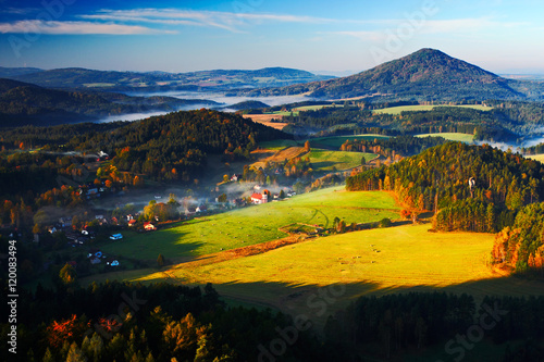 Czech typical autumn landscape. Hills and villages with foggy morning. Morning fall valley of Bohemian Switzerland park. Hills with fog  landscape of Czech Republic  Jetrichovice  Ceske Svycarsko.