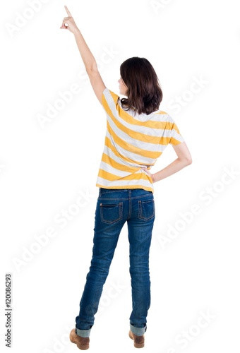 Back view of pointing woman. beautiful brunette girl in yellow striped t-shirt. Rear view people collection. backside view of person. Isolated over white background.