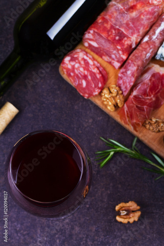 Red wine with blue cheese, parmesan, salami, prosciutto, olives, rosemary and bread. View from above, top studio shot