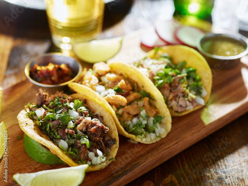 three different mexican street tacos with beef and pork