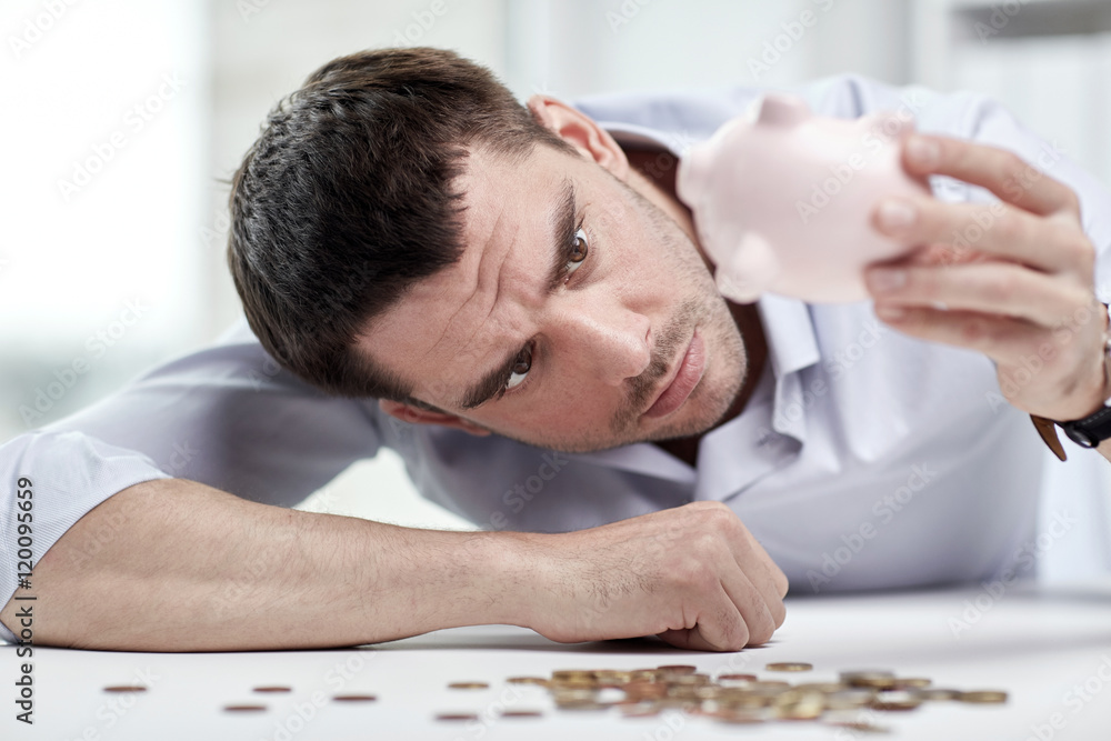 Obraz premium businessman with piggy bank and coins at office
