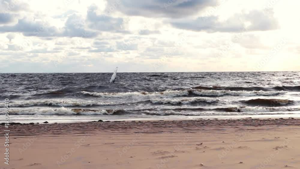 Windsurfing, Surfer moving on windsurf board along the beach coastline. Waves, clouds, sand, wind. Windsurfing, Surfer moving on windsurf board along the beach coastline. Waves, clouds, sand, wind.