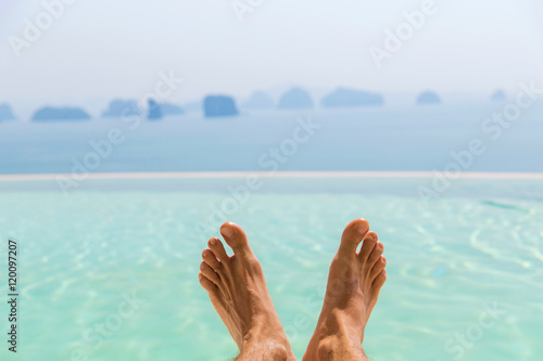 closeup of male feet over sea and sky on beach