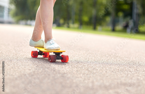 close up of female feet riding short skateboard