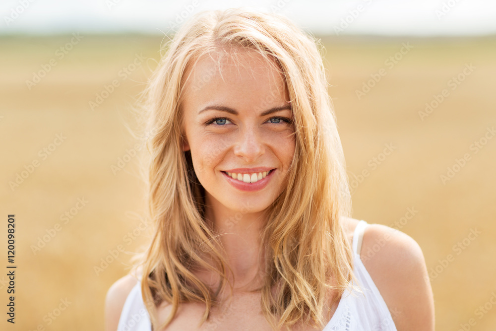 Fototapeta premium smiling young woman in white on cereal field