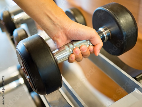 Woman hold dumbbell weights at gym ready for weightlifting exercise.