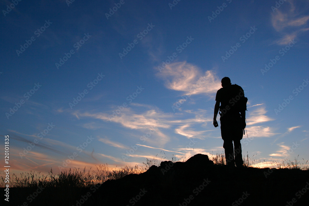Silhouette eines einsamen Wanderers mit Rucksack gegen den Nachthimmel