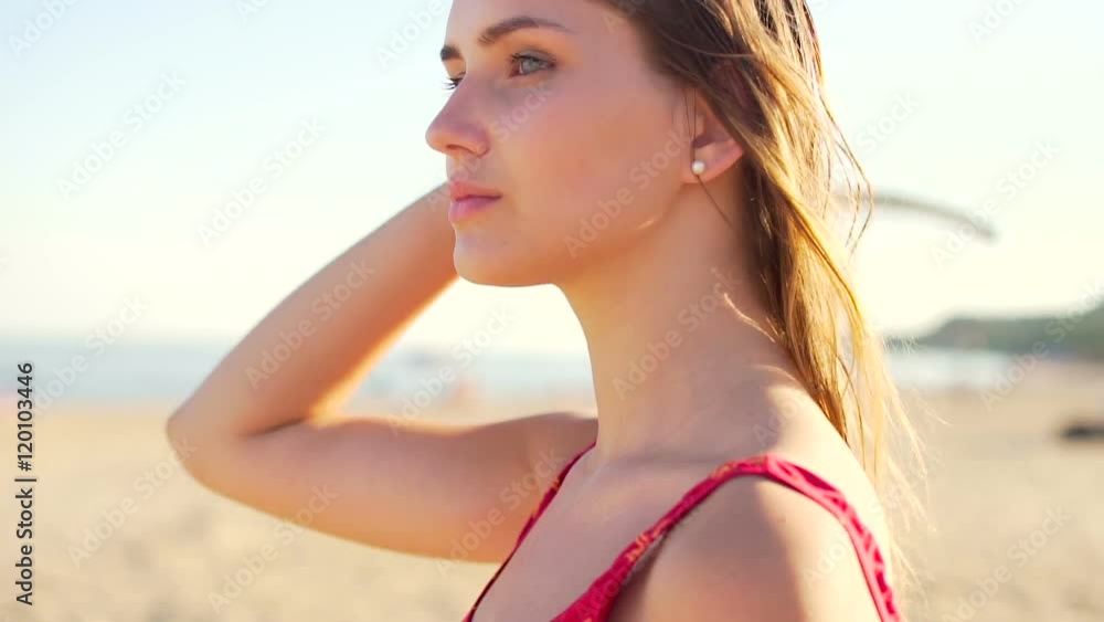 Handsome woman in swimwear walking across beach and enjoying. Close up tracking shot Handsome woman in swimwear walking across beach and enjoying. Close up tracking shot