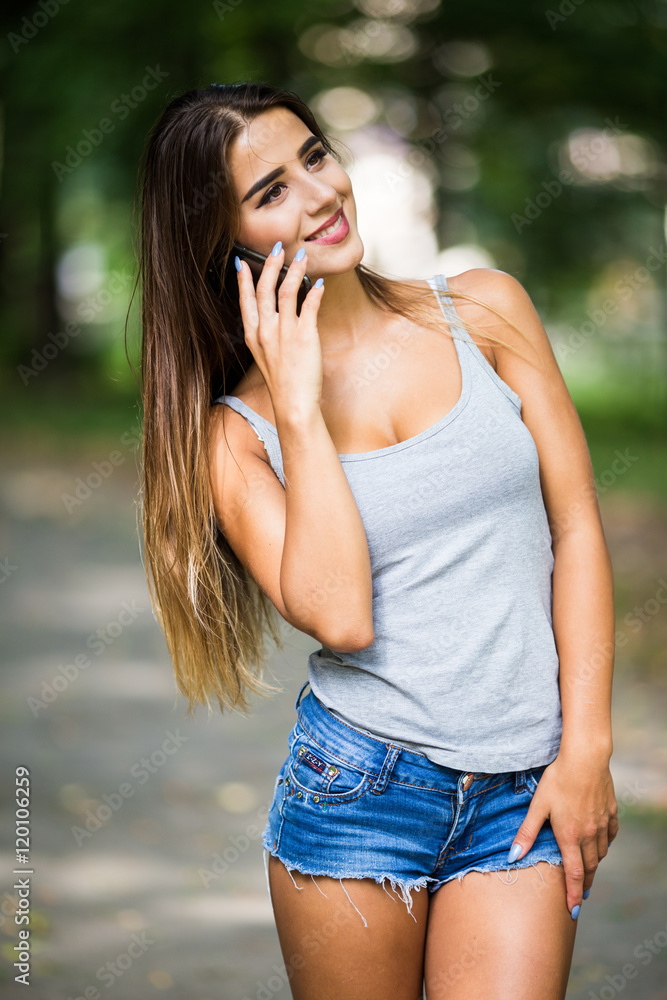 Beautiful woman talking on cell phone in the park